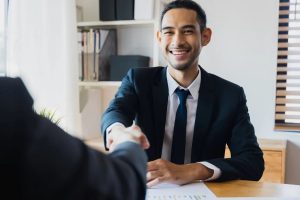 The worker shakes hands and smiles at the work desk